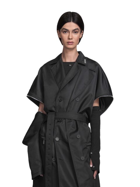 Cropped View of Model Vitoria Mota wearing the Spina Coat from BAD PORTIER's OPERATION AW25 capsule. The outlier piece is a long, layered coat with detachable sleeves, side zippers and adjustable waist for modular structure.