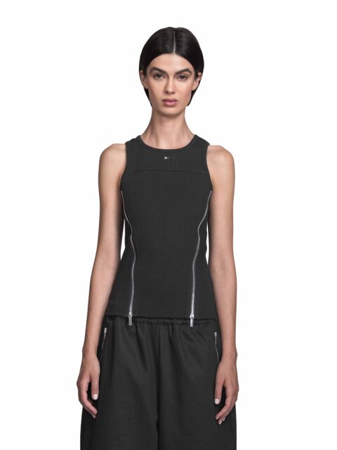 Cropped front View of Model Vitoria Mota wearing the Sternum Tanktop Black from BAD PORTIER's OPERATION AW25 capsule showing the logo and the front zipper of the slim cotton tank with two diagonal chrome zippers and panel seams for a sharp V-shape.